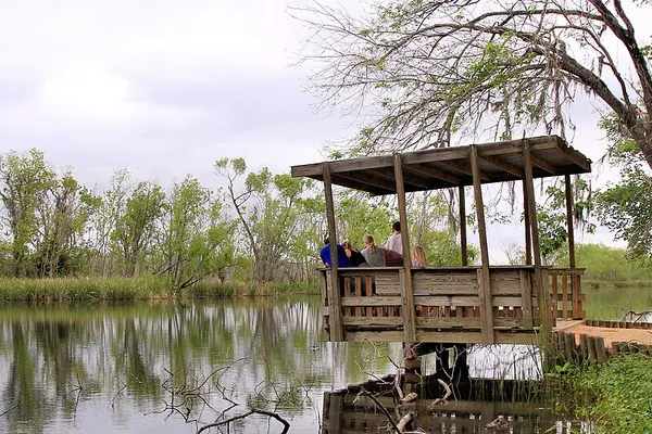 A family on a wooden viewing platform over Elm Lake at Brazos Bend State Park