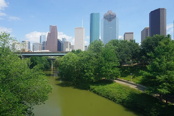 Buffalo Bayou Park trees and water with the downtown Houston skyline behind