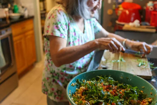 Tossing a big bowl of salad in a Houston home kitchen