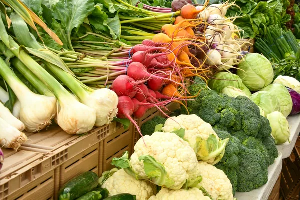Fresh vegetables piled on a farmers market stall